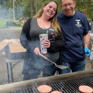 Exectuive Director and TCI employee cooking at the grill