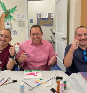 Three men, smiling and thumbs up, at Paint Night