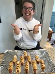 Smiling proud TCI member with smiley pigs in blankets that he cooked